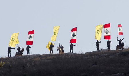 Siegesparade: Anhänger der Hisbollah schwenken Fahnen auf einer ...