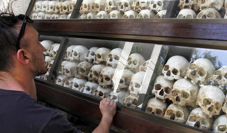 Besucher in einer Gedenkstätte für die Opfer der »Killing Fields... Besucher in einer Gedenkstätte für die Opfer der »Killing Fields...