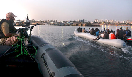 Libysche Marinekräfte zwingen ein Boot mit Flüchtlingen in einen... Libysche Marinekräfte zwingen ein Boot mit Flüchtlingen in einen...