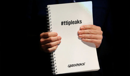 Greenpeace-Mitglied mit einer Kopie der geleakten TTIP-Dokumente...