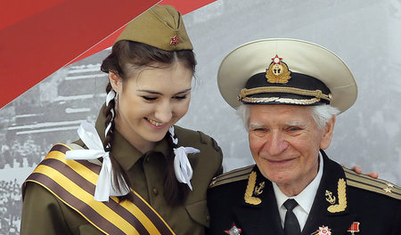 Eine junge Frau und ein alter Veteran in sowjetischen Uniformen ...