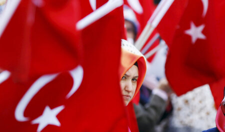 Gülen-Anhängerin mit türkischer Flagge auf einer Demonstration i...