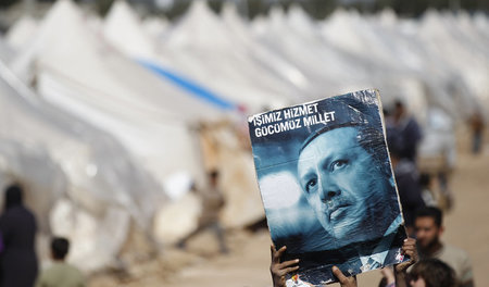 Syrische Flüchtlinge im Lager Reyhanli zeigen ein Bild des türki...