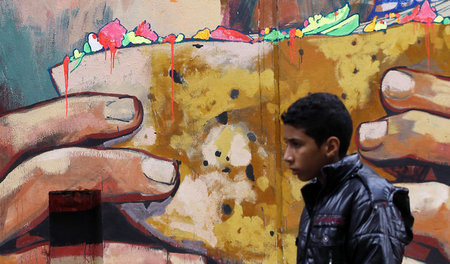 Junge vor Graffiti zum Thema Armut in Kairo: Das neue Kreditprog...