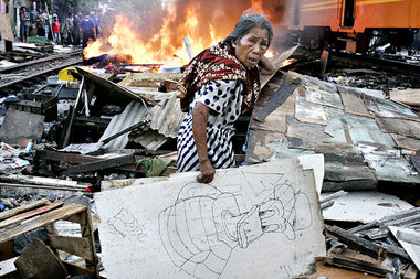 Bettlerin in Jakarta vor ihrer zerstörten Behausung Bettlerin in Jakarta vor ihrer zerstörten Behausung