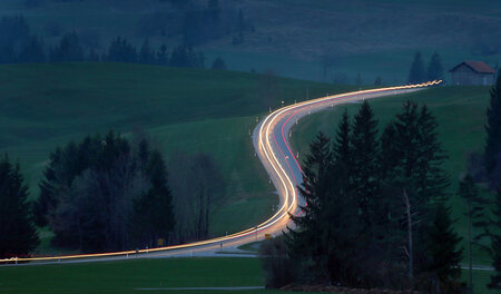Zu schnell für Bonuspunkte? Lichtspur eines Pkw auf Landstraße i...