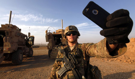Schnappschuss aus dem Krieg: Ein US-Soldat beim Knipsen eines Se... Schnappschuss aus dem Krieg: Ein US-Soldat beim Knipsen eines Se...