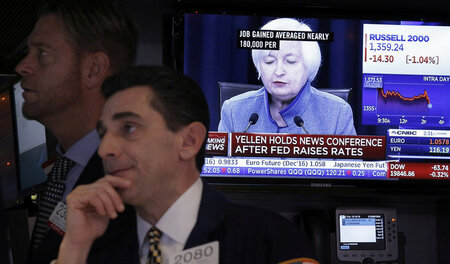 Mit Dollarzeichen in den Augen lauscht ein Broker an der New Yor...