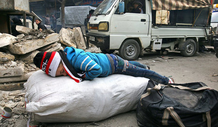 Ost-Aleppo am Samstag: Ein Kind wartet mit anderen Einwohnern au... Ost-Aleppo am Samstag: Ein Kind wartet mit anderen Einwohnern au...