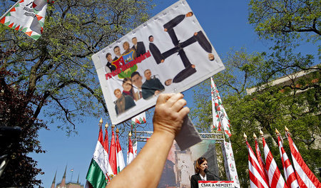 Jobbik-Politiker formen ein hakenkreiz: Protest während einer Ku... Jobbik-Politiker formen ein hakenkreiz: Protest während einer Ku...