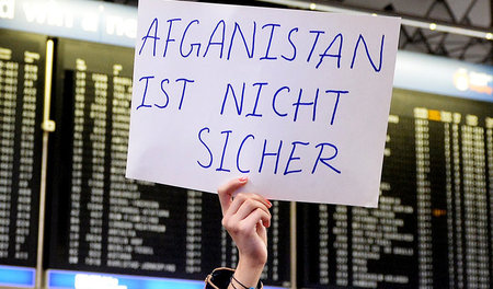 Eine Frau protestiert am 14. Dezember auf dem Flughafen Frankfur...