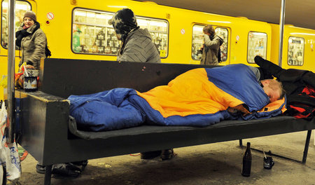 Ein Obdachloser auf einer Bank in der Berliner U-Bahnstation am ...