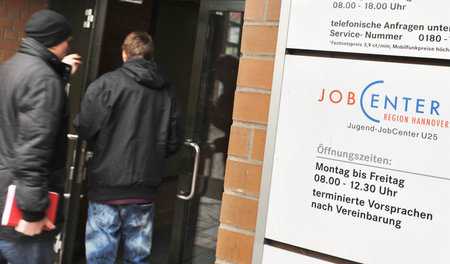 Zwei Männer betreten in Hannover ein Jobcenter (24. Januar 2012)