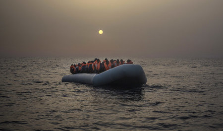 Menschen, die die Überfahrt nach Europa auf solchen Schlauchboot...