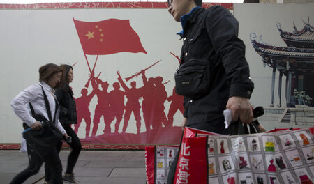 Auf einem Graffitto halten chinesische Soldaten die Landesfahne ...