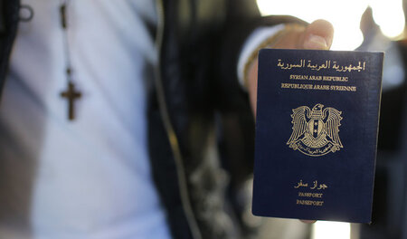 Ein syrischer Flüchtling zeigt seinen Pass im Pariser Flughafen ...