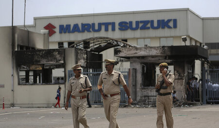 Polizisten vor der ausgebrannten Fabrik in Manesar (19. Juli 201...