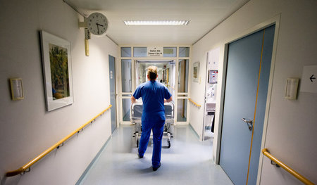 Ohne Unterstützung rollen Pflegekräfte Betten über die Krankenha...