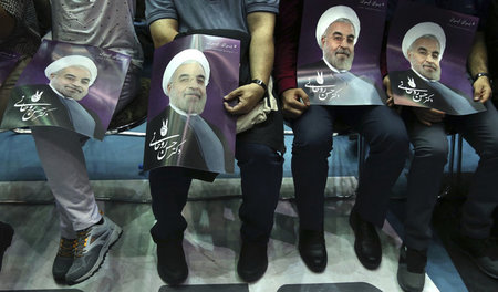 Unterstützer des iranischen Präsidenten Hassan Rohani mit Plakat...