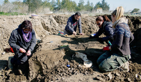 Griechische und türkische ­Archäologen beim Ausgraben eines Opfe...