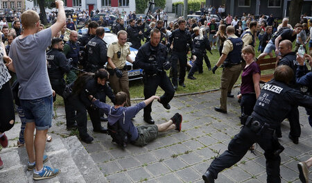 Die Polizei geht gegen Schüler vor, die mit einer Sitzblockade d...