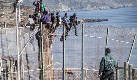 Migranten versuchen am 3. April 2014 einen mit Stacheldraht vers...