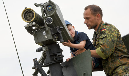 Deutscher Soldat zeigt dem drei Jahre alten Ben das Boden-Boden-... Deutscher Soldat zeigt dem drei Jahre alten Ben das Boden-Boden-...