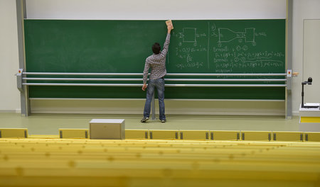 Ein wissenschaftlicher Mitarbeiter putzt in einem Hörsaal der Un...