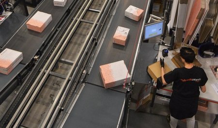 Zalando-Mitarbeiter verpacken in einem Logistikzentrum die Ware,...