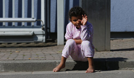 Ein Flüchtlingskind sitzt vor einer Notunterkunft in Ingelheim b... Ein Flüchtlingskind sitzt vor einer Notunterkunft in Ingelheim b...