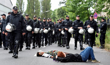 Protestieren im Liegen vor schwarzem Polizeiblock auf der Demo g...