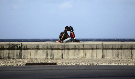 Liebe in Kuba: Ein küssenden Paar auf der Strandpromenade in Hav... Liebe in Kuba: Ein küssenden Paar auf der Strandpromenade in Hav...