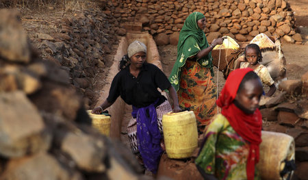 Frauen und Mädchen der Burji schöpfen nahe Marsabit in Kenia Was... Frauen und Mädchen der Burji schöpfen nahe Marsabit in Kenia Was...