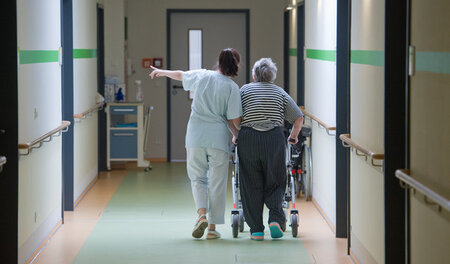 Eine Krankenschwester führt eine Patienten auf ihr Zimmer, hier ...