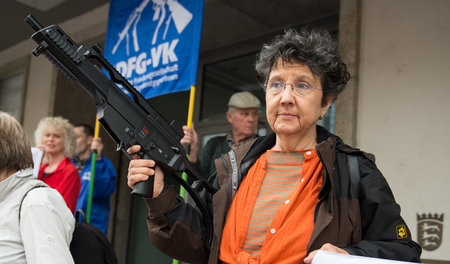 Eine Frau hält die Replik eines Gewehrs G36 von Heckler & Koch b...