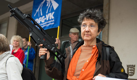 Eine Frau hält die Replik eines Gewehrs G36 von Heckler & Koch b...