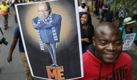 Zuma nicht mehr beliebt beim Volk: Demonstrant mit dem Bild des ...