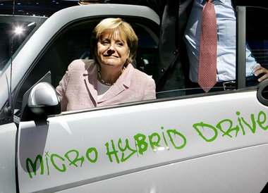Für die Kameras setzt sich Angela Merkel auch in ein Hybridauto ...