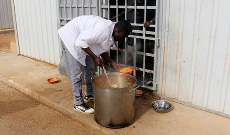 Festung Libyen? Flüchtlinge hinter Gittern, während ein Camp-Mit...