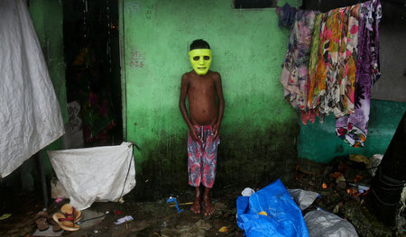 Schutz vor dem Regen sucht dieser Junge in einem Slum von Mumbai