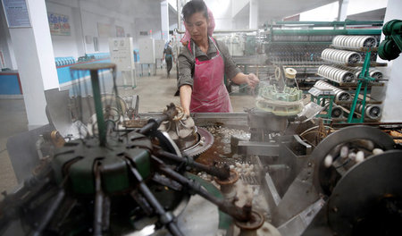 Eine Arbeiterin der Kim-Jong-Suk-Textilfabrik in Pjöngjang, Nord... Eine Arbeiterin der Kim-Jong-Suk-Textilfabrik in Pjöngjang, Nord...