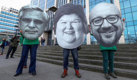 Belgier mit Masken ihrer führenden Politiker bei einer Arbeiterk... Belgier mit Masken ihrer führenden Politiker bei einer Arbeiterk...