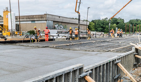Arbeiter gießen eine Betonplatte zur Stabilisierung des Tunnels ...